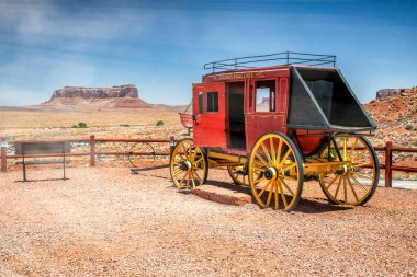Güneşli bir yaz gününde Monument Valley manzaralı ahşap renkli bir karavan.