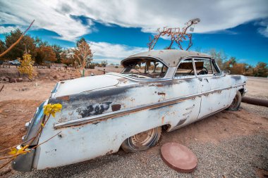 Mavi gökyüzünün altında paslı eski arabalar. Eski model araçlar.