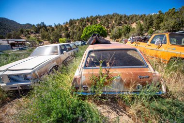 GLENSDALE, UT - 20 Haziran 2018: Mavi bir yaz gökyüzü altında paslı eski arabalar.