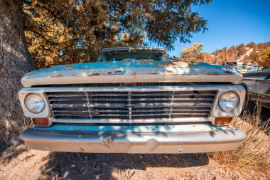 Mavi gökyüzünün altında paslı eski arabalar. Eski model araçlar.