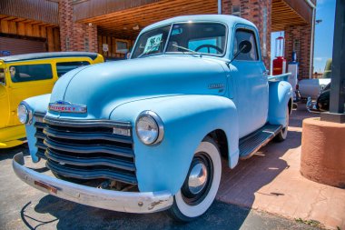 WILLIAMS, AZ - 29 Haziran 2018: 66 numaralı ünlü güzergahtaki şehirlerden biri olan Williams 'taki hediyelik eşya dükkanlarının önündeki klasik arabalarla sokak sahnesi