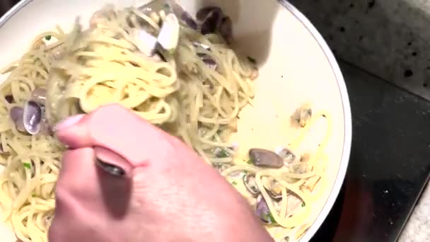 Egy nő spagettit főz kagylóval, gőzzel a serpenyőből. Lassú mozgás. — Stock videók