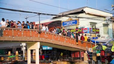 Amphawa, Tayland - 15 Aralık 2019: Turistler gün batımında bir köprü boyunca şehir manzarasının tadını çıkarıyorlar