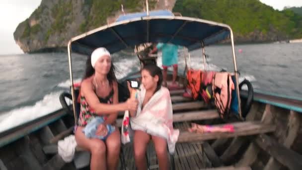 Chica joven en un barco de cola larga utilizando la cámara de acción disfrutando del viaje con su madre — Vídeo de stock