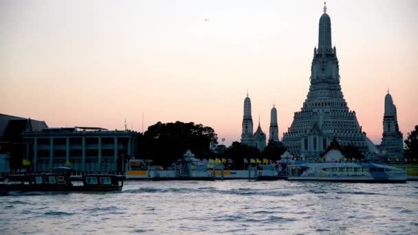 Bangkok, Таїланд - 14 грудня 2019: Boats on the Chao Phraya river front of Wat Arun at sunset — стокове відео