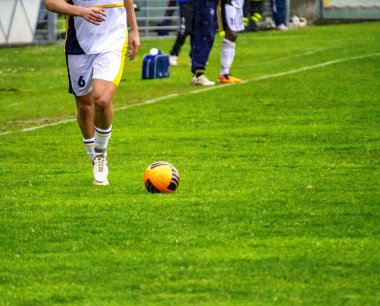 Profesyonel futbol ya da futbol oyuncusu stadyumda topa vuruyor.
