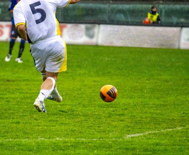 Profesyonel futbol ya da futbol oyuncusu stadyumda topa vuruyor.
