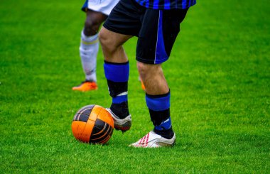 Futbol oyuncuları futbol sahasında top için mücadele ediyorlar.