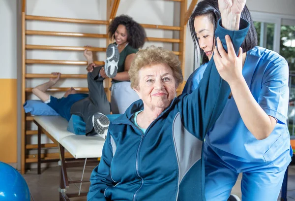 Feliz Pareja Seniors Sonriendo Entrenamiento Gimnasio Ayudado Por Entrenadores Asiáticos —  Fotos de Stock