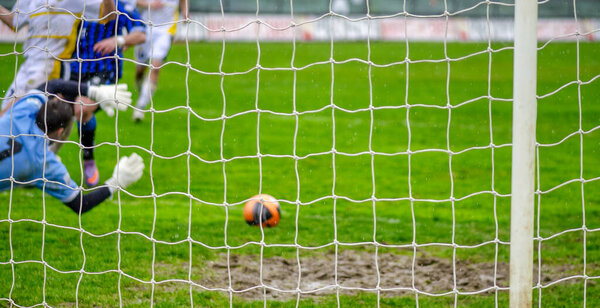 Blurred view of professional football or soccer goalkeeper in action on stadium defending