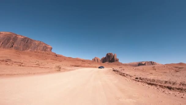 MONUMENT VALLEY, EE.UU. - JULIO 2019: Cruzando el Cañón en temporada de verano, vista desde la parte delantera del coche — Vídeos de Stock