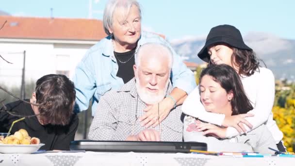 Man som förklarar hur man använder elektrisk piano utomhus för sina barnbarn — Stockvideo