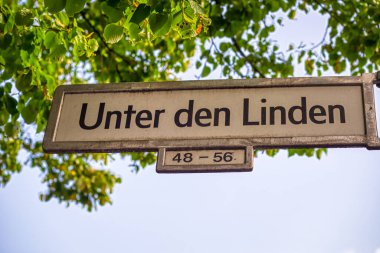 Berlin ağaçlarının altındaki Linden Caddesi tabelasına kadar.