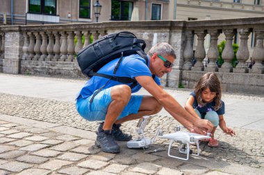 Adam uçmadan önce İHA 'sını kuruyor, kızı da ona yardım ediyor.