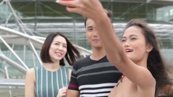 Trois jeunes asiatiques en plein air relaxant dans la ville — Video