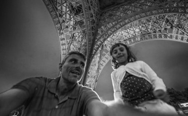 Geceleri kızıyla Eyfel Towet 'nin altında bir adam.