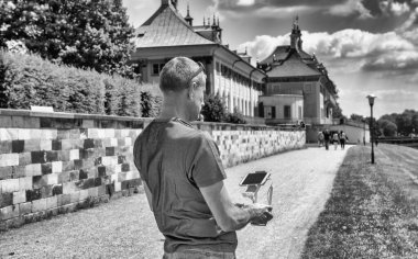 Dışarıdaki adam uzaktan kumandayı kullanarak İHA 'sını kontrol ediyor.