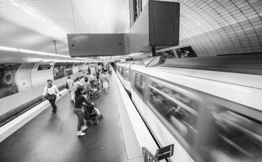 Paris, Fransa - 22 Temmuz 2014: Metro istasyonunda hareket eden yeraltı treniyle turistler ve yerel halk