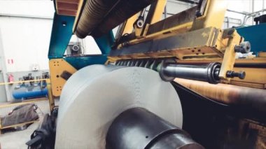 Endüstriyel makineler çalışıyor. Metal bobinler kesiliyor