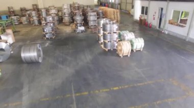 Depoda depolanmış galvanizli çelik rulo var. Hava aracının görüntüsü var.