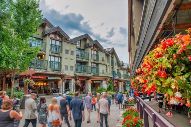 Whistler, Kanada - 12 Ağustos 2017: Güneşli bir günde şehir merkezini ziyaret eden turistler. Whistler ünlü bir turistik dağ beldesidir.