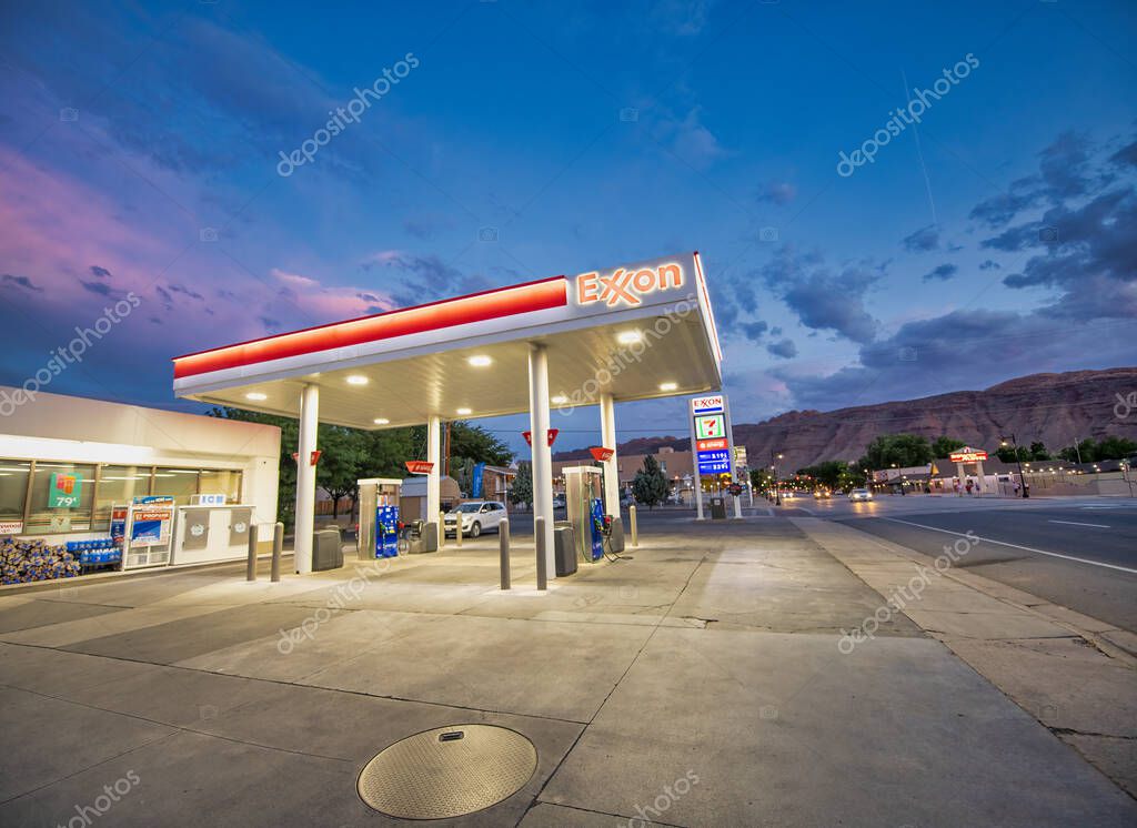 Moab, Utah - June 30, 2019: Exxon gas station at night with red colors and cars refueling