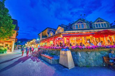 Whistler, Kanada - 12 Ağustos 2017: Turistler gece şehir merkezini ziyaret ederler. Whistler ünlü bir turistik dağ beldesidir.
