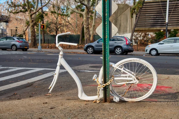 Брошенный Белый Велосипед Одним Колесом Прикованным Столбу Вдоль Городской Улицы — стоковое фото
