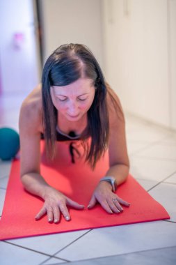 Kadın salgın zamanında evde paspasın üstünde çalışıyor.