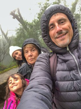 Mutlu üç kuşak Kafkas ailesi kış günü dışarıda selfie çekiyor.