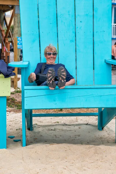 Elderly Woman Sitting Very Big Chair Outdoor Smiling While Holiday — Stockfoto