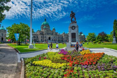 Vancouver Island, Canada - August 15, 2017: Tourists in front of British Columbia Parliament Buildings in Victoria clipart