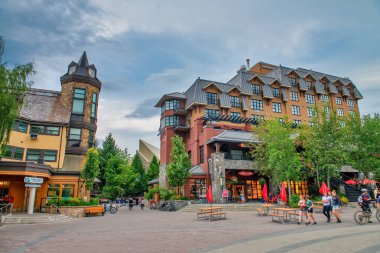 Whistler, Kanada - 12 Ağustos 2017: Güneşli bir günde şehir merkezini ziyaret eden turistler. Whistler ünlü bir turistik dağ beldesidir.