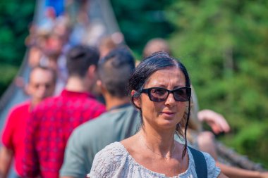 Vancouver 'da Capilano Cliff Walk Askı Köprüsü' nü geçen mutlu kadın.