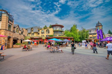 Whistler, Kanada - 12 Ağustos 2017: Güneşli bir günde şehir merkezini ziyaret eden turistler. Whistler ünlü bir turistik dağ beldesidir.