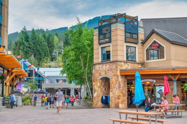 Whistler, Kanada - 12 Ağustos 2017: Güneşli bir günde şehir merkezini ziyaret eden turistler. Whistler ünlü bir turistik dağ beldesidir.