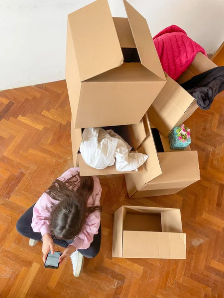 Moving New Home Concept Young Girl Seated Cardboard Boxes Parquet — Φωτογραφία Αρχείου