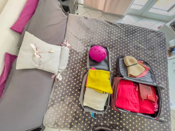 把你的度假手提箱放在床上 带上衣服和帽子 旅行时的行李 — 图库照片