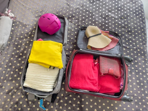 服や帽子でベッドの上にあなたの休暇のスーツケースをパック 旅行のための梱包 — ストック写真