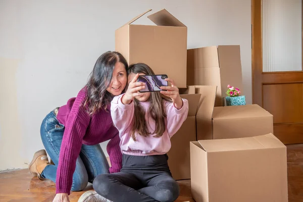 Moving New Home Concept Young Girl Her Mother Seated Cardboard — Stockfoto