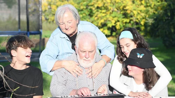 Man Legt Uit Hoe Elektrische Piano Outdoor Gebruiken Zijn Kleinkinderen — Stockfoto