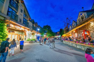 Whistler, Kanada - 12 Ağustos 2017: Turistler gece şehir merkezini ziyaret ederler. Whistler ünlü bir turistik dağ beldesidir.