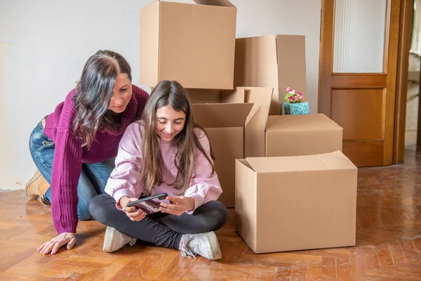 Moving New Home Concept Young Girl Her Mother Seated Cardboard — Φωτογραφία Αρχείου