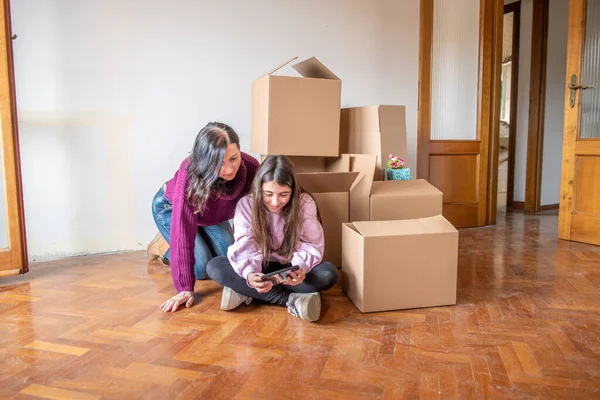 Moving New Home Concept Young Girl Her Mother Seated Cardboard — Φωτογραφία Αρχείου