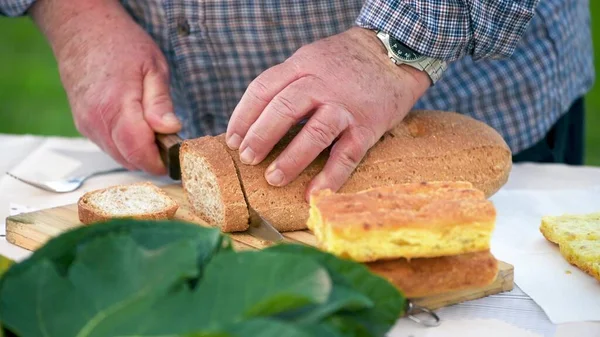 Uomo Che Taglia Pane Tavolo All Aperto — Foto Stock