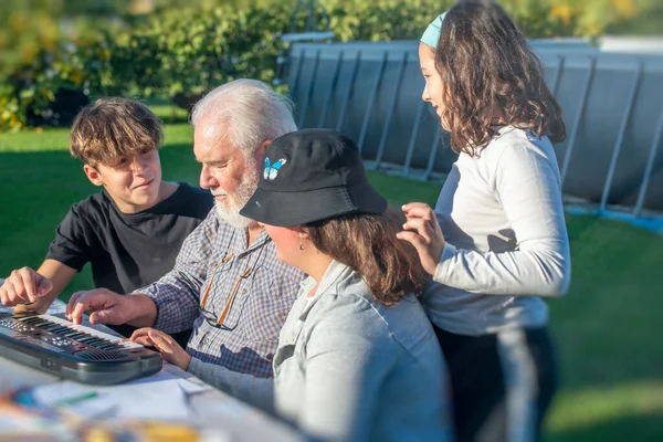 Grandfather Explains How Use Piano His Grandchildren Outdoor — Foto de Stock