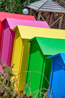 Colorful wooden cabins along the beach.