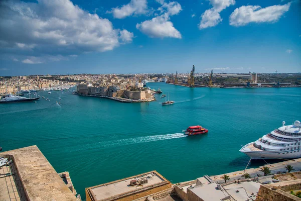La Valletta, Malta - 17 Nisan 2022: Günbatımında teknelerle üç şehirde Cospicua.