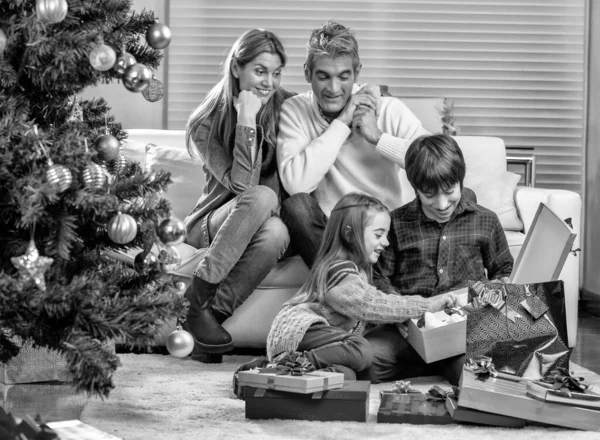 クリスマスのために家で幸せな笑顔の白人家族クリスマスプレゼントをアンラッピング — ストック写真