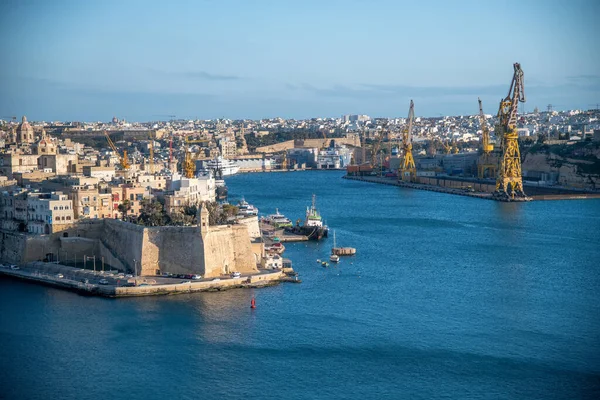 La Valletta, Malta - 17 Nisan 2022: Günbatımında teknelerle üç şehirde Cospicua.